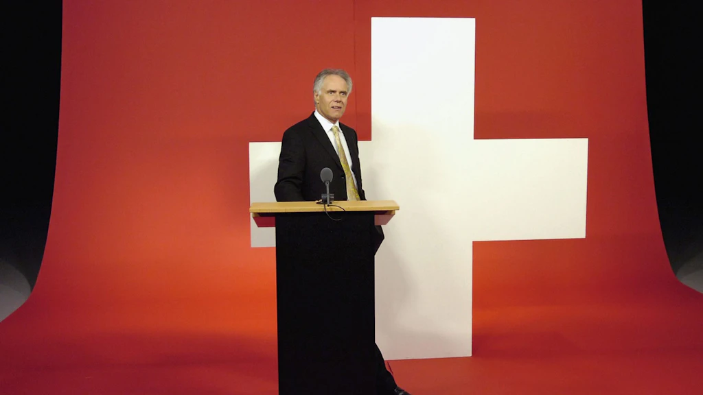 Bundespräsident Moritz Leuenberger steht an einem Rednerpult vor einer grossen Schweizer Flagge.