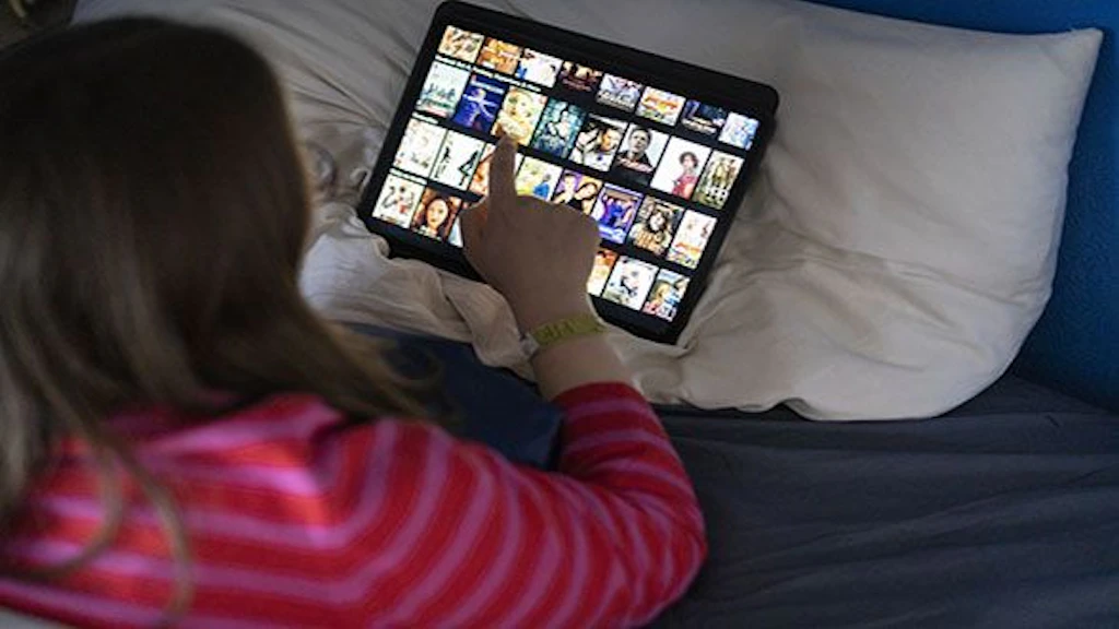 Eine Frau schaut sich das Programm des Streaminganbieters Netflix auf dem Tablet an.