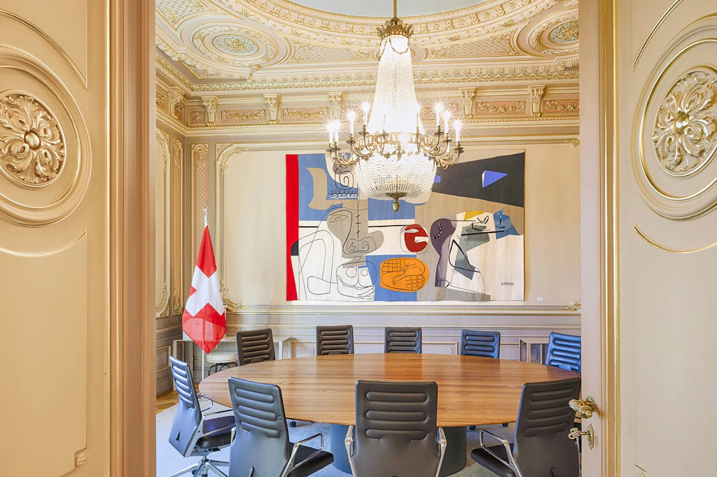 Besprechungszimmer im Rokoko-Stil mit Rundtisch, Le-Corbusier-Tapisserie und Schweizer Flagge