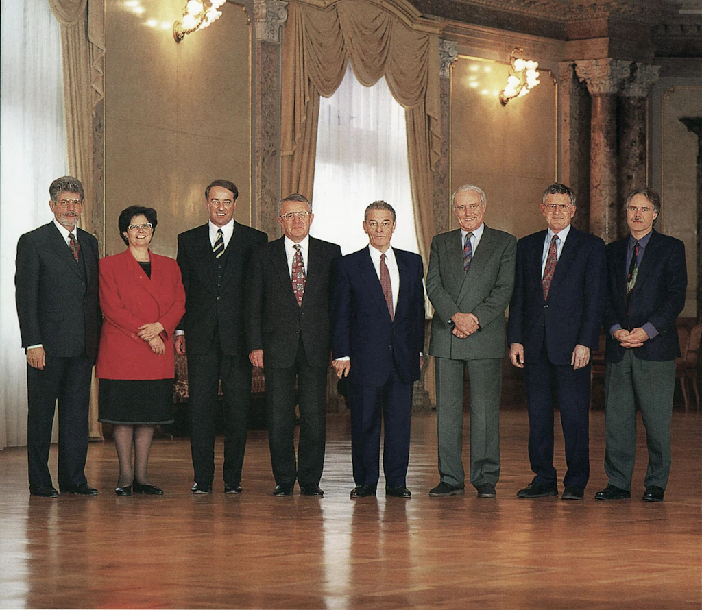 Le Conseil fédéral 1996 in corpore (de gauche à droite): le chancelier de la Confédération François Couchepin, la conseillère fédérale Ruth Dreifuss, le conseiller fédéral Adolf Ogi, le conseiller fédéral Arnold Koller, le président de la Confédération Jean-Pascal Delamuraz, le conseiller fédéral Flavio Cotti, le conseiller fédéral Kaspar Villiger, le conseiller fédéral Moritz Leuenberger