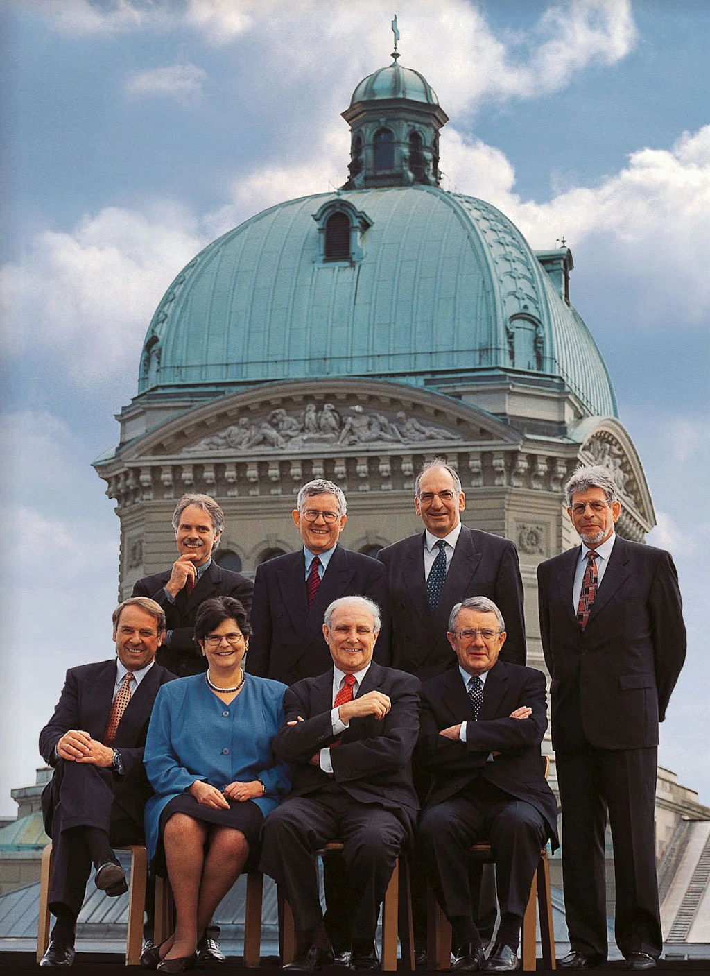 Le Conseil fédéral 1998 in corpore (de gauche à droite): le conseiller fédéral Adolf Ogi, le conseiller fédéral Moritz Leuenberger, la conseillère fédérale Ruth Dreifuss, le conseiller fédéral Kaspar Villiger, le président de la Confédération Flavio Cotti, le conseiller fédéral Pascal Couchepin, le conseiller fédéral Arnold Koller, le chancelier de la Confédération François Couchepin