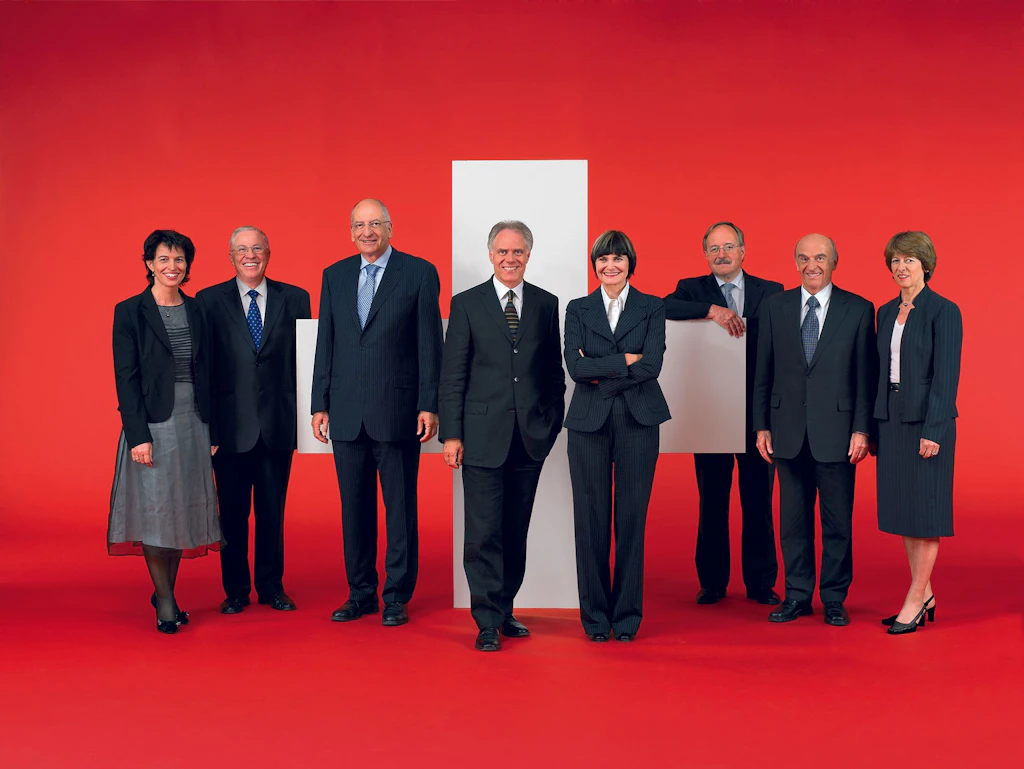 Le Conseil fédéral 2006 in corpore (de gauche à droite): la conseillère fédérale Doris Leuthard, le conseiller fédéral Christoph Blocher, le conseiller fédéral Pascal Couchepin, le président de la Confédération Moritz Leuenberger, la conseillère fédérale Micheline Calmy-Rey, le conseiller fédéral Samuel Schmid, le conseiller fédéral Hans-Rudolf Merz, la chancelière de la Confédération Annemarie Huber-Hotz